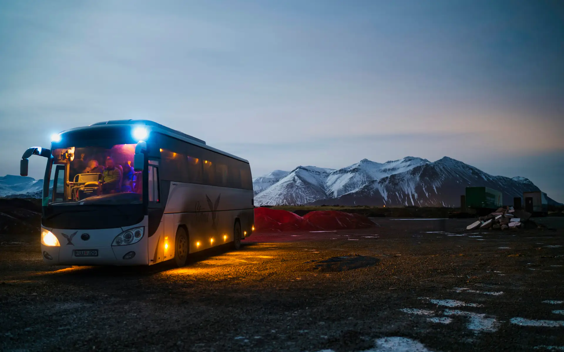 Luxury motor coach for large group travel, lit up at dusk