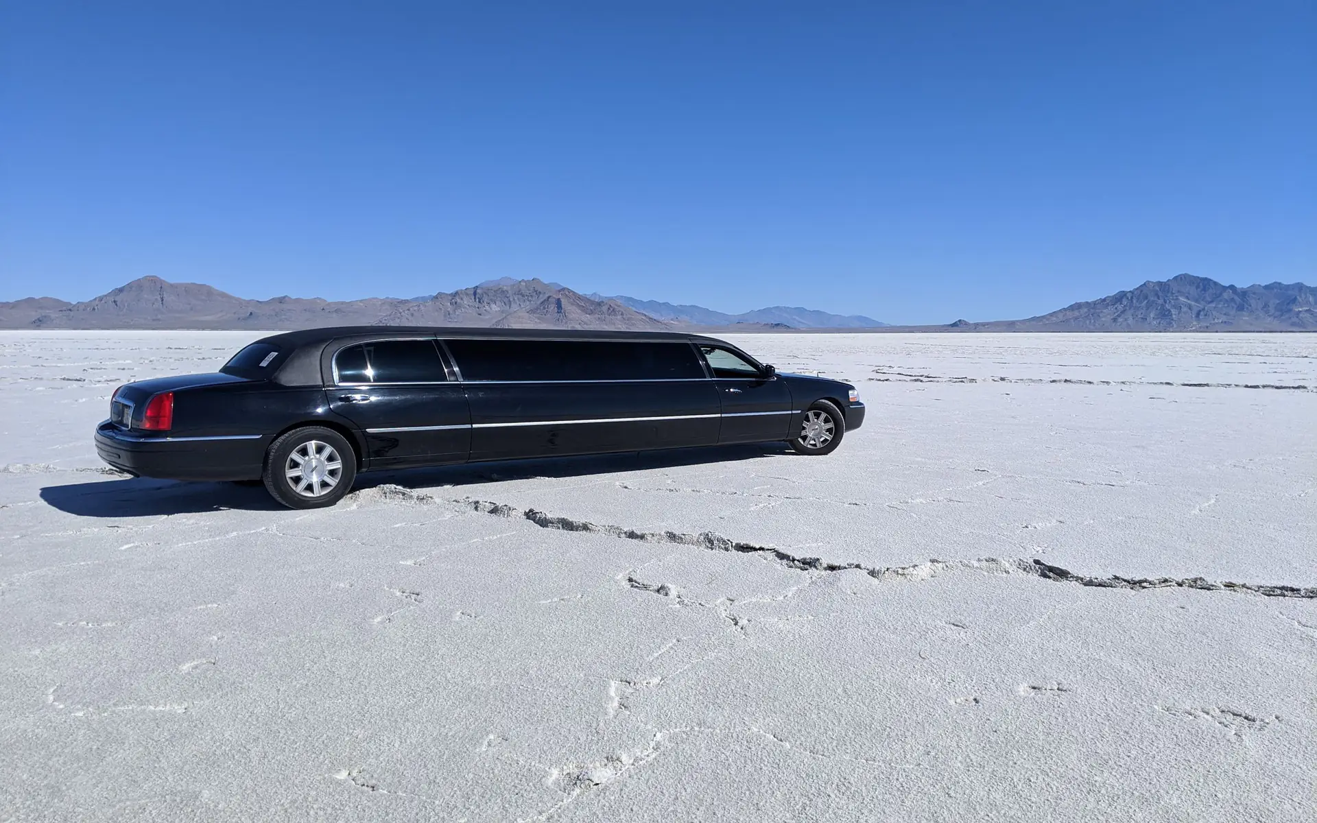 Black stretch limo parked on open salt flats