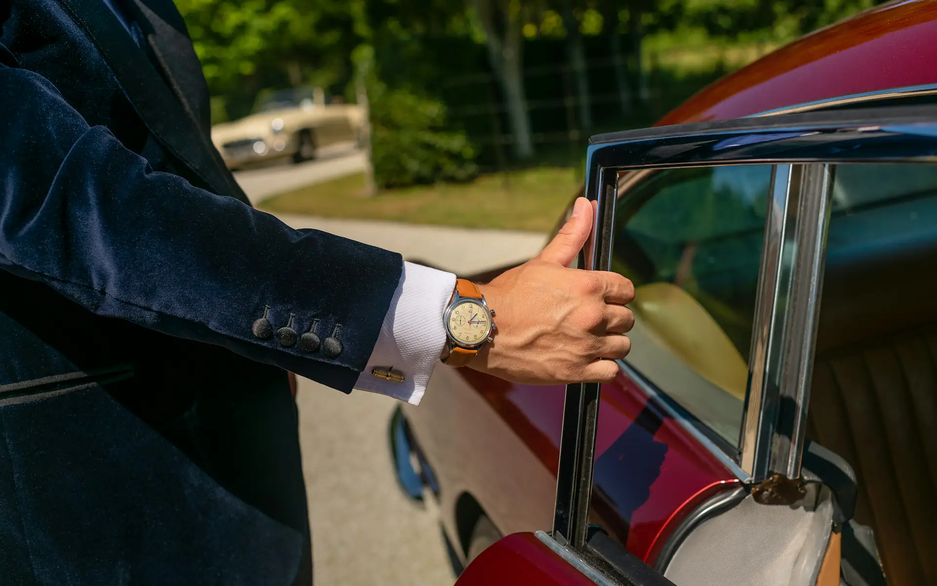Chauffeur in a tailored suit opening the rear door of a car